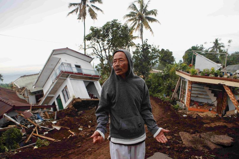 &copy; Reuters. Un homme près de maisons gravement endommagées après le tremblement de terre de lundi à Cianjur en Indonesia. /Photo prise le 25 novembre 2022/REUTERS/Ajeng Dinar Ulfiana