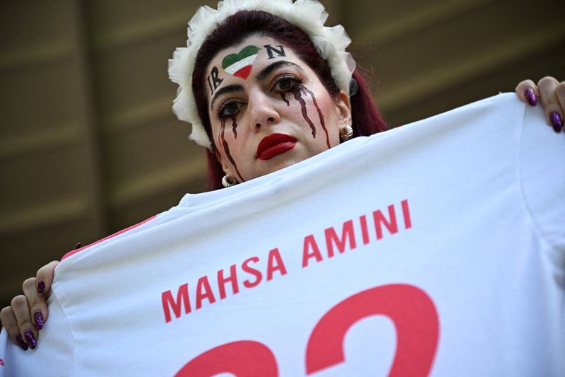 &copy; Reuters. Torcedora segura camiseta com nome de mulher curda morta sob custódia da polícia moral do Irã durante partida entre Irã e País de Gales na Copa do Mundo do Catar
25/11/2022 REUTERS/Dylan Martinez