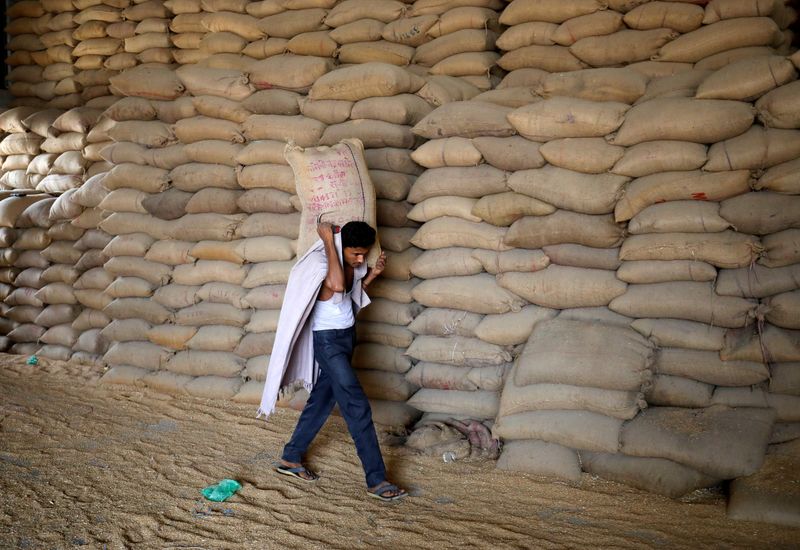 &copy; Reuters. FOTO DE ARCHIVO: Un trabajador carga un saco de trigo para tamizarlo en un molino de grano en las afueras de Ahmedabad, India, el 16 de mayo de 2022. REUTERS/Amit Dave