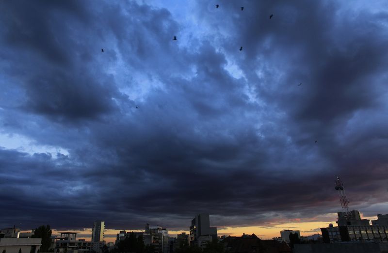 © Reuters. FILE PHOTO: Clouds gather over Bucharest's skyline at dusk September 24, 2013. REUTERS/Radu Sigheti/File Photo