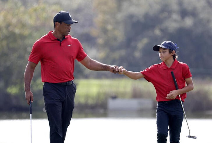 &copy; Reuters. 　男子ゴルフでメジャー通算１５勝を誇るタイガー・ウッズ（左）が、来月開催のＰＮＣ選手権に１３歳の息子チャーリー君（右）と出場する。大会主催者が２５日に発表した。写真は昨年