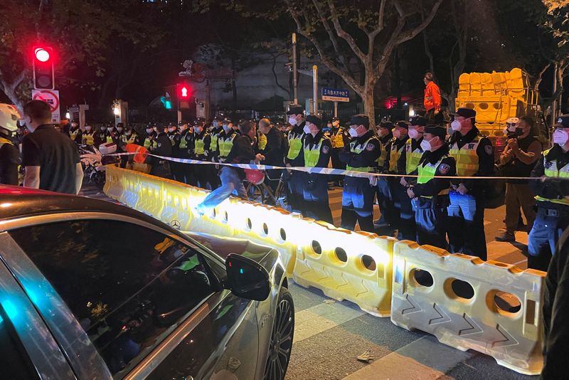 © Reuters. Oficiales de policía se ubican detrás de las barricadas en Shanghái, China, 27 noviembre del 2022. REUTERS/Josh Horwitz/Foto de Archivo