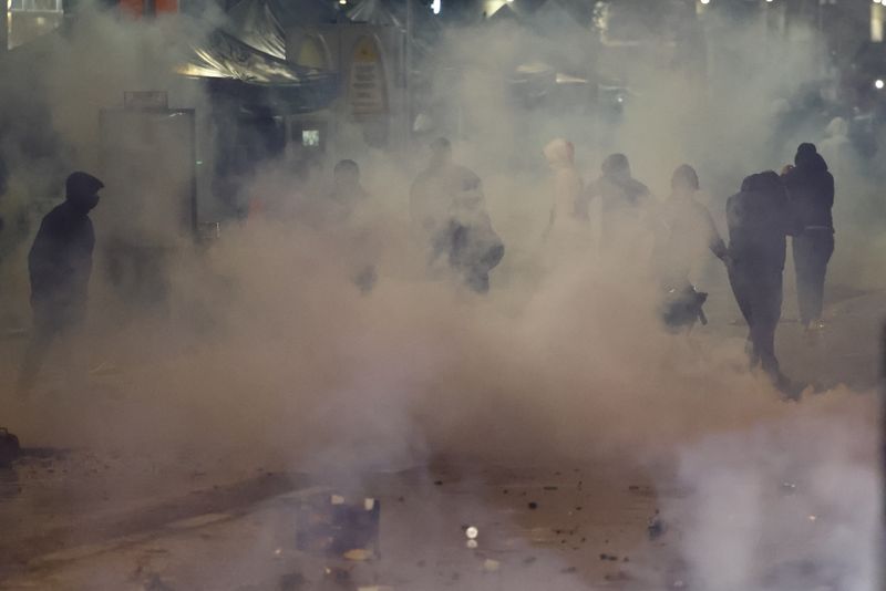 © Reuters. اشتباكات في بروكسل عقب مباراة بلجيكا والمغرب في كأس العالم لكرة القدم بقطر يوم الأحد والشرطة تحاول تفريق مجموعة من الأشخاص وسط الدخان. تصوير : إيف إيرمان - رويترز .  