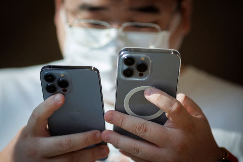 &copy; Reuters. Homem olha para iPhones em uma loja da Apple, enquanto os novos modelos de iPhone 14 da Apple são colocados à venda em Pequim, China. 16/09/2022. REUTERS/Thomas Peter/File Photo