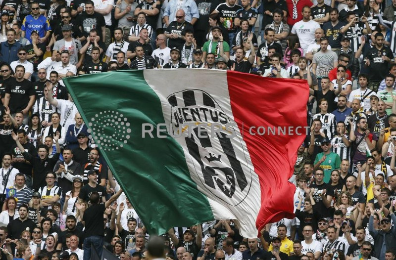 &copy; Reuters. Il logo della Juventus su una bandiera italiana allo Juventus Stadium di Torino. 5 maggio 2013. REUTERS/Stefano Rellandini (ITALY - Tags: BUSINESS LOGO SPORT SOCCER)