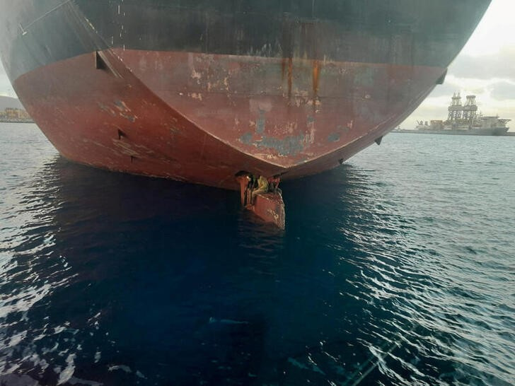 &copy; Reuters.  Tres migrantes en la pala del timón del buque petrolero Althini II después de viajar desde Nigeria y antes de ser rescatados por la guardia costera española, en esta foto publicada en la cuenta oficial de Twitter de Salvamento Marítimo, en el mar cer