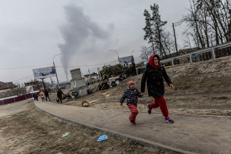 &copy; Reuters. Des résidents courent pour se mettre à l'abri à Irpin, dans la banlieue Ouest de Kyiv, après un bombardement. /Photo prise le 6 mars 2022REUTERS/Carlos Barria