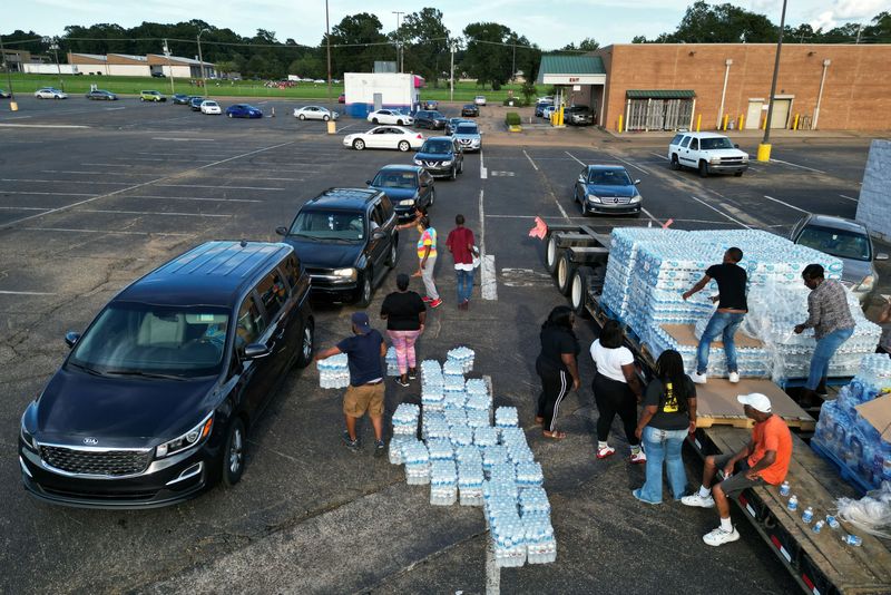 © Reuters. FILE PHOTO: Volunteers help to carry bottles of water at a water distribution site as the city of Jackson is to go without reliable drinking water indefinitely after pumps at the water treatment plant failed, leading to the emergency distribution of bottled water and tanker trucks for 180,000 people, in Jackson, Mississippi, U.S., August 31, 2022. REUTERS/Eric Cox