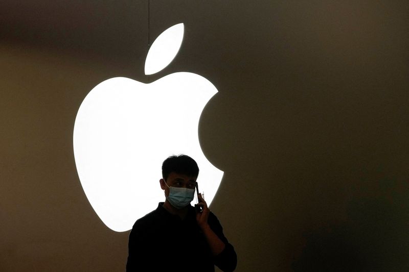 © Reuters. FILE PHOTO: A man talks on a phone in front of an Apple logo outside its store, following the coronavirus disease (COVID-19) outbreak in Shanghai, China, November 7, 2022. REUTERS/Aly Song