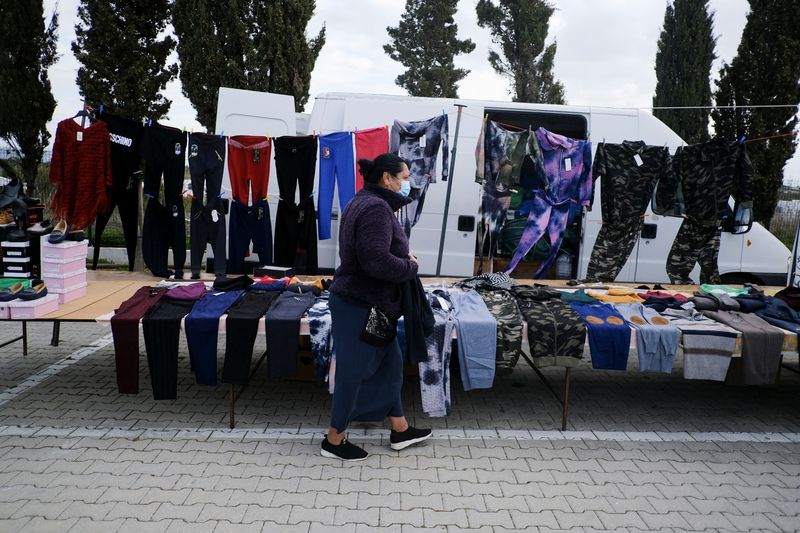 &copy; Reuters. FILE PHOTO: A Roma community woman takes care of the clothes she sells at a street market, in Faro, Portugal, January 26, 2022. Picture taken January 26, 2022. REUTERS/Pedro Nunes