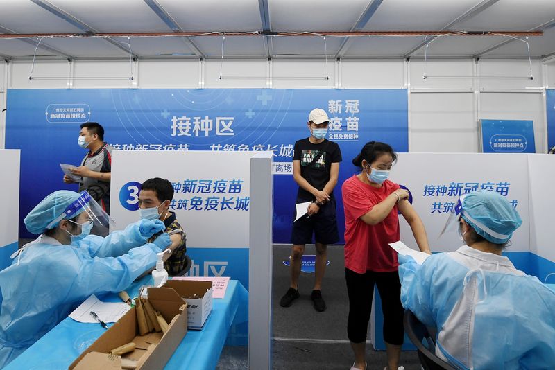 &copy; Reuters. FOTO DE ARCHIVO. Residentes reciben vacunas contra la enfermedad del coronavirus (COVID-19) en un centro de vacunación improvisado en Cantón, provincia de Guangdong, China. 21 de junio de 2021. cnsphoto vía REUTERS