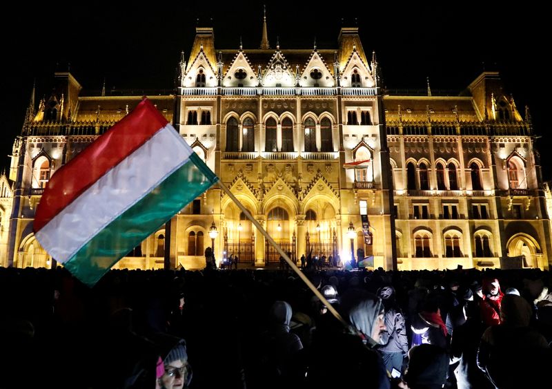 &copy; Reuters. Photo d'archives : Un manifestant tient un drapeau national hongrois lors d'une manifestation contre un projet de nouvelle loi sur le travail, à Budapest, en Hongrie. /Photo prise le 5 janvier 2019/REUTERS/Bernadett Szabo