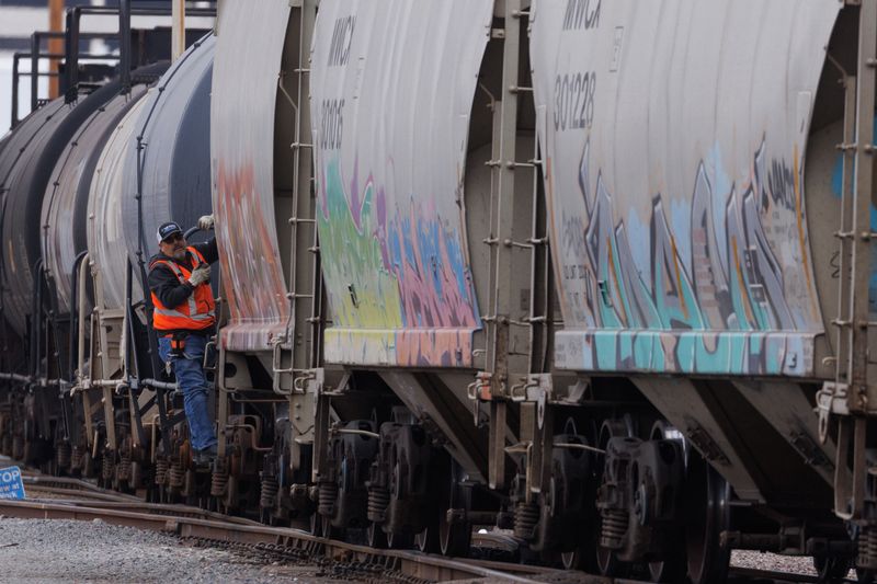 © Reuters. A railway worker helps load railcars onto a train in San Diego, California, U.S., November 30, 2022. REUTERS/Mike Blake
