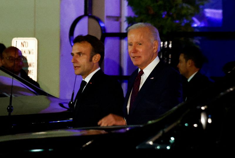 © Reuters. U.S. President Joe Biden and French President Emmanuel Macron walk next to vehicles as they meet for dinner at Fiola Mare restaurant in the Georgetown neighborhood of Washington, U.S., November 30, 2022.  REUTERS/Evelyn Hockstein