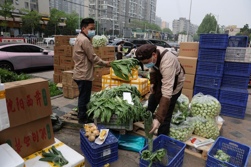 &copy; Reuters. FOTO DE ARCHIVO: Miembros del personal clasifican las verduras cerca de un mercado callejero, en medio de la pandemia de COVID-19, en Pekín, China. 25 de abril, 2022. REUTERS/Tingshu Wang/Archivo