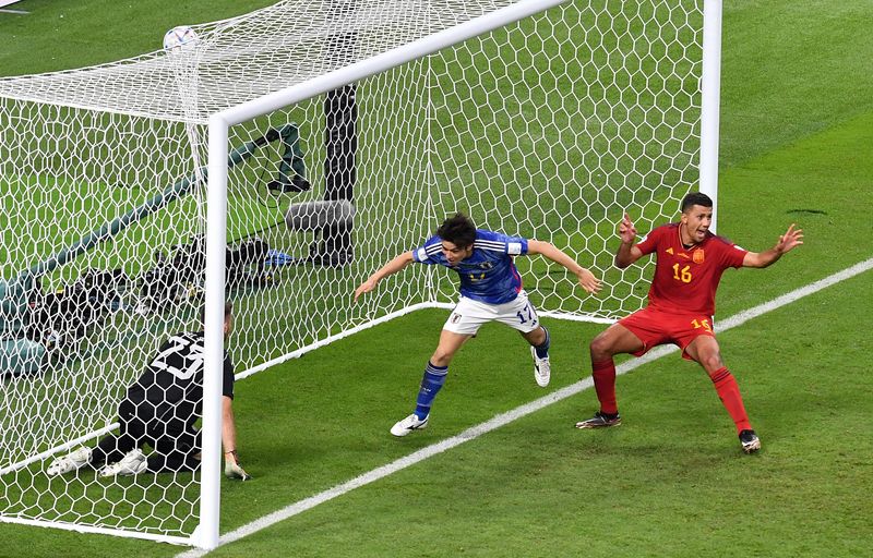 Soccer-Inspired Japan roar back again to shock Spain and top group