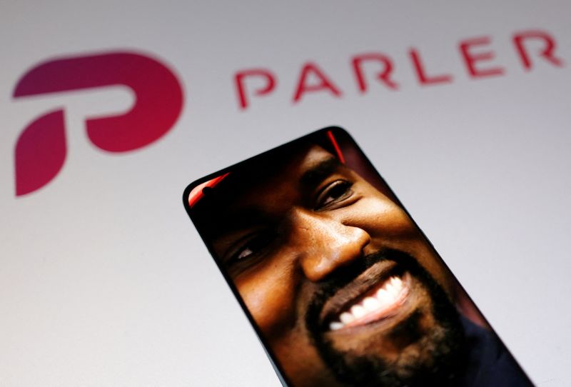 © Reuters. American rapper Kanye West's picture is seen on a smartphone in front of the logo of social media app Parler in this Illustration taken, October 17, 2022. REUTERS/Dado Ruvic/Illustration