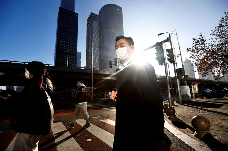 &copy; Reuters. FILE PHOTO: People walk across a street during morning rush hour, following the outbreak of the coronavirus disease (COVID-19), in the Central Business District (CBD) in Chaoyang District, Beijing, China November 21, 2022. REUTERS/Tingshu Wang/File Photo