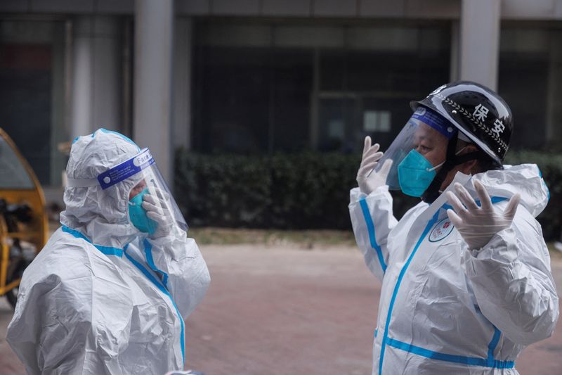 © Reuters. Pandemic prevention workers in protective suits get ready to enter an apartment building that went into lockdown as coronavirus disease (COVID-19) outbreaks continue in Beijing, December 2, 2022. REUTERS/Thomas Peter