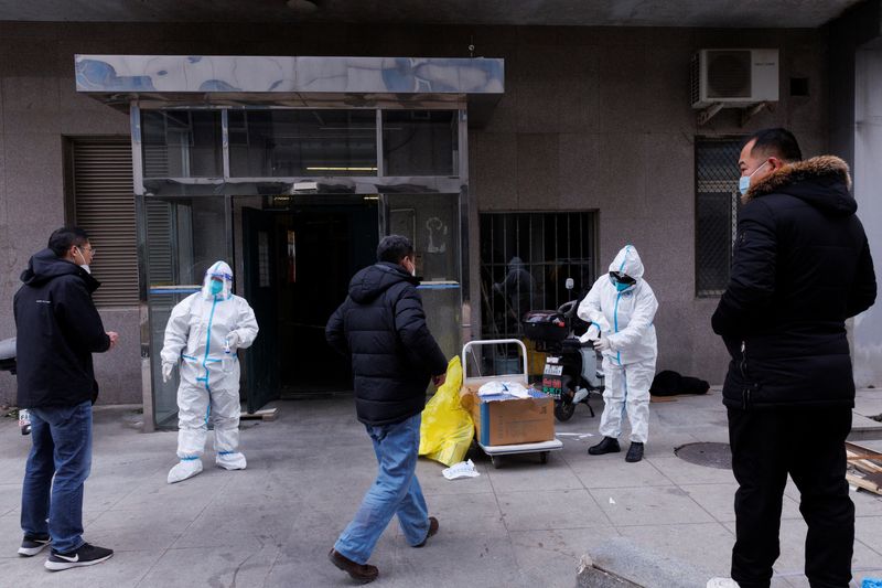 &copy; Reuters. Trabajadores con trajes de protección se preparan para entrar en un edificio de apartamentos que entró en cuanrentena mientras los brotes de la enfermedad del coronavirus (COVID-19) continúan en Pekín, 2 de diciembre de 2022. REUTERS/Thomas Peter