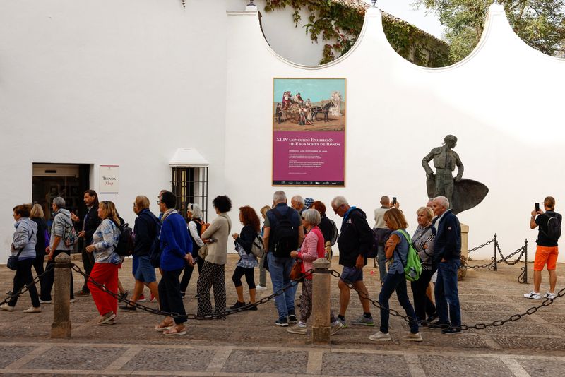 &copy; Reuters. Tourists walk during a tour in Ronda, Spain, October 4, 2022. REUTERS/Jon Nazca/File Photo