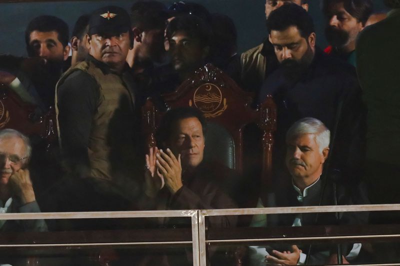 &copy; Reuters. FILE PHOTO: Pakistan's former Prime Minister, Imran Khan, gestures from behind a bullet-proof glass window, in his first public appearance since him being wounded in a gun attack earlier this month, during so-called 'a true freedom march' to pressure the 
