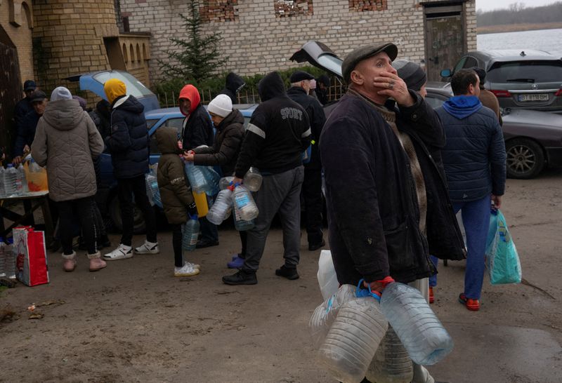 &copy; Reuters. Des personnes remplissent des bouteilles d'eau près du fleuve Dniepr après la retraite militaire russe de Kherson. /Photo prise le 22 novembre 2022/REUTERS/Anna Voitenko   
