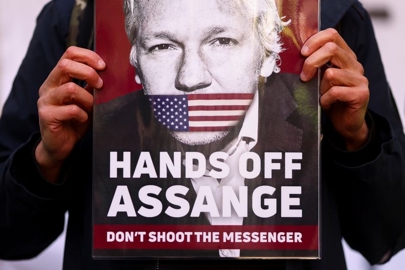 &copy; Reuters. Un soutien de Julian Assange montre une pancarte avec son visage devant le tribunal de Westminster à Londres. /Photo prise le 20 avril 2022/REUTERS/Tom Nicholson