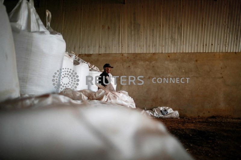 &copy; Reuters. FOTO DE ARCHIVO: Un trabajador agrícola junto a sacos de fertilizante antes de esparcirlo en un campo de soja, cerca de Brasilia, Brasil. 15 de febrero de 2022. REUTERS/Adriano Machado/