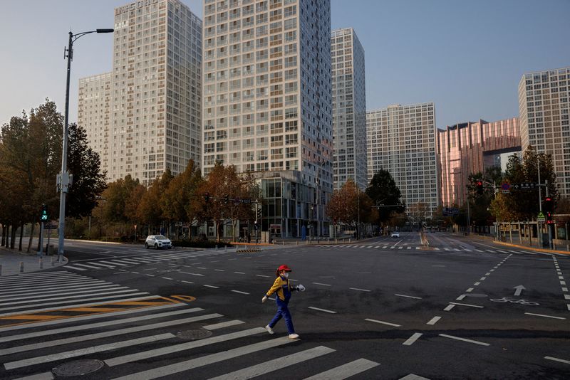 &copy; Reuters. Photo d'archives: Une femme traverse une rue à l'heure de pointe du matin après que des ordres de télétravail aient maintenu le Central Business District (CBD) largement vide alors que les épidémies de coronavirus (COVID-19) se poursuivent à Pékin