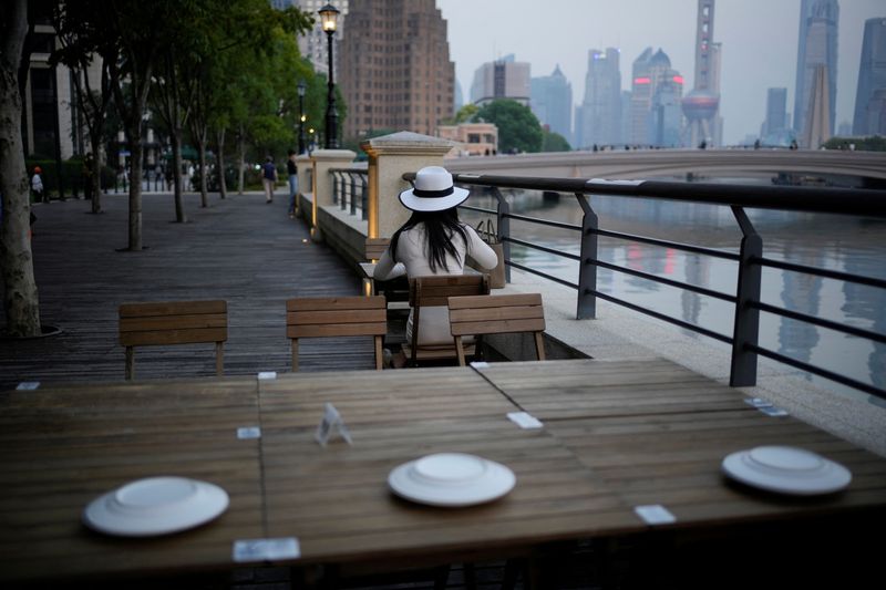 &copy; Reuters. FOTO DE ARCHIVO: Una mujer se sienta en un restaurante a la orilla de un río, tras el brote de COVID-19, en Shanghái, China. 6 de septiembre, 2022. REUTERS/Aly Song/Archivo