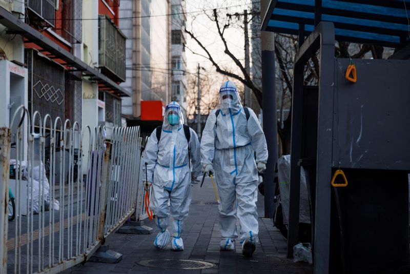 &copy; Reuters. Trabajadores de prevención de pandemias con trajes de protección caminan por una calle mientras continúan los brotes de la enfermedad por coronavirus (COVID-19) en Pekín, el 4 de diciembre de 2022. REUTERS/Thomas Peter