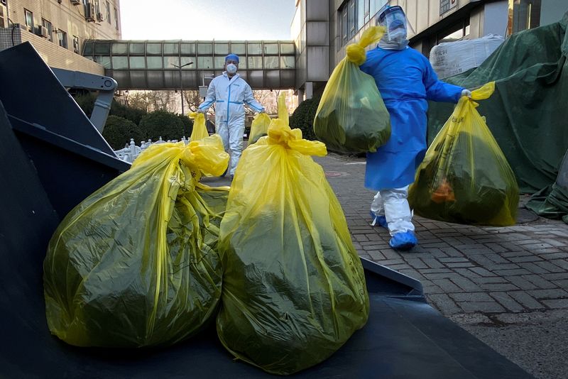 &copy; Reuters. Workers in protective suits remove bags of medical waste outside a building where residents isolate at home as coronavirus disease (COVID-19) outbreaks continue in Beijing, China December 5, 2022. REUTERS/Thomas Peter