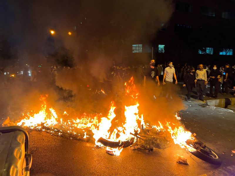 &copy; Reuters. Una motocicleta de la policía arde durante una protesta por la muerte de Mahsa Amini, una mujer que falleció después de ser arrestada por la "policía de la moralidad" de la república islámica, en Teherán, Irán, el 19 de septiembre de 2022. WANA (A