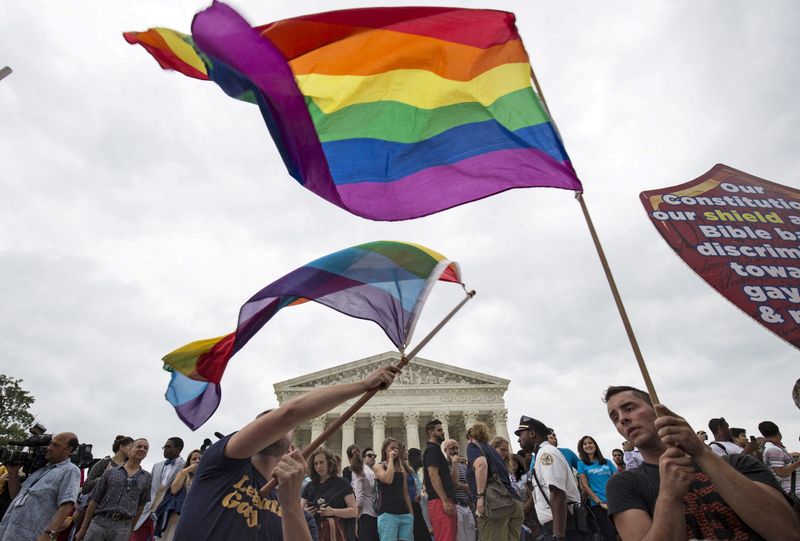 © Reuters. FILE PHOTO: Supporters of gay marriage wave the rainbow flag after the U.S. Supreme Court ruled that the U.S. Constitution provides same-sex couples the right to marry at the court building in Washington June 26, 2015. REUTERS/Joshua Roberts/File Photo