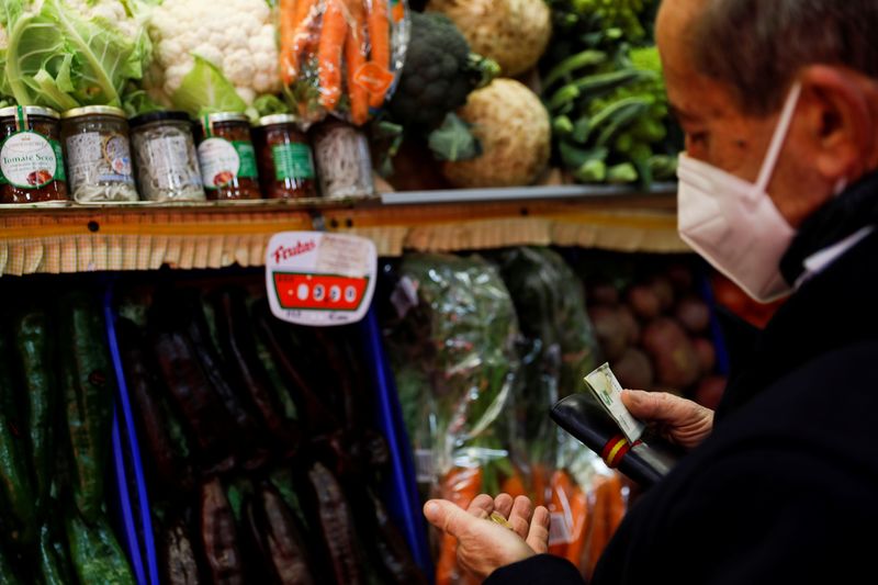 &copy; Reuters. FOTO DE ARCHIVO: Un hombre paga en una frutería en un mercado de Madrid, España, 29 de noviembre de 2021. REUTERS/Susana Vera