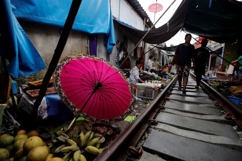 &copy; Reuters. FILE PHOTO: A woman walks at the Maeklong market next to the train tracks, on the outskirts of Bangkok, Thailand September 21, 2016. REUTERS/Jorge Silva/File Photo