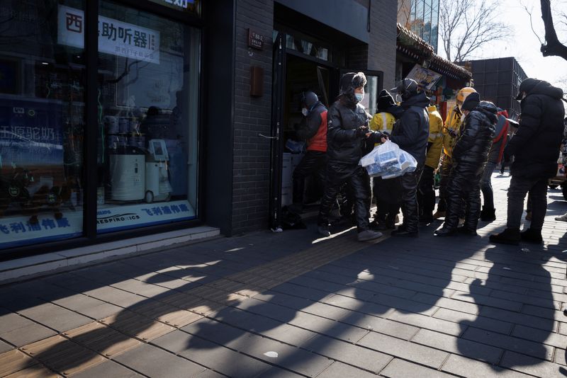 &copy; Reuters. Un chauffeur livreur récupère des médicaments dans une pharmacie alors que les épidémies de coronavirus (COVID-19) se poursuivent à Pékin. /Photo prise le 7 décembre 2022/REUTERS/Thomas Peter