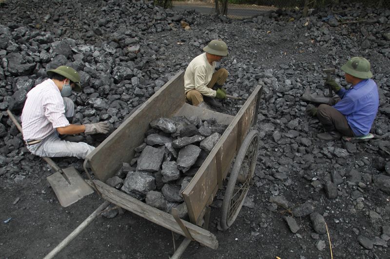 &copy; Reuters. FOTO DE ARCHIVO: Trabajadores recogen grava de carbón en un depósito de carbón en Hanoi