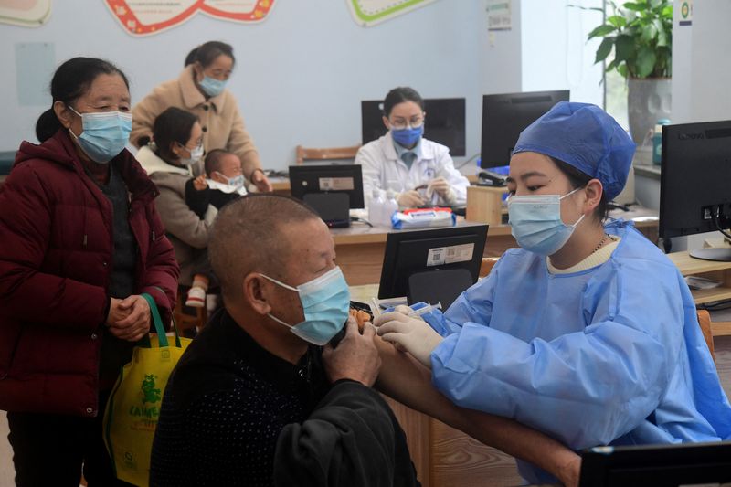 &copy; Reuters. FOTO DE ARCHIVO. Una trabajadora sanitaria administra una dosis de la vacuna contra la enfermedad por coronavirus (COVID-19) a un anciano residente en un centro de servicios sanitarios comunitarios de Jinhua, provincia china de Zhejiang, China. 5 de dicie