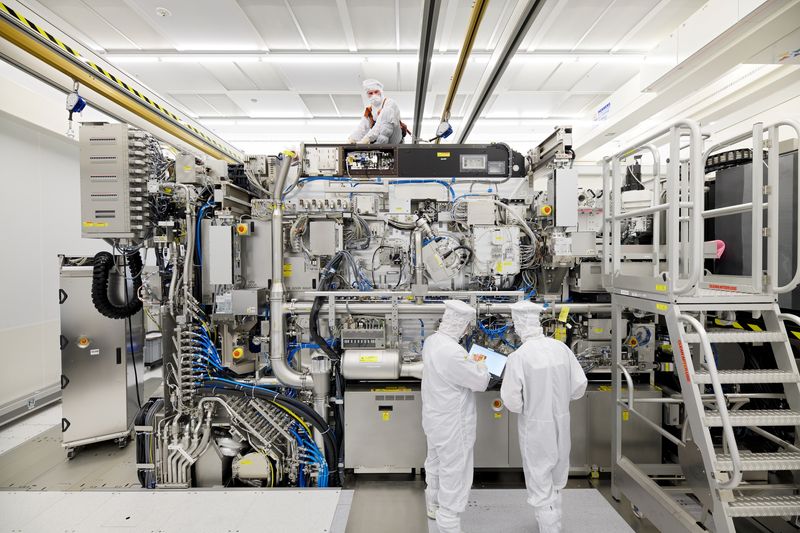 &copy; Reuters. Employees are seen working on the final assembly of ASML's TWINSCAN NXE:3400B semiconductor lithography tool with its panels removed, in Veldhoven, Netherlands, in this picture taken April 4, 2019. Bart van Overbeeke Fotografie/ASML/Handout via REUTERS/Fi