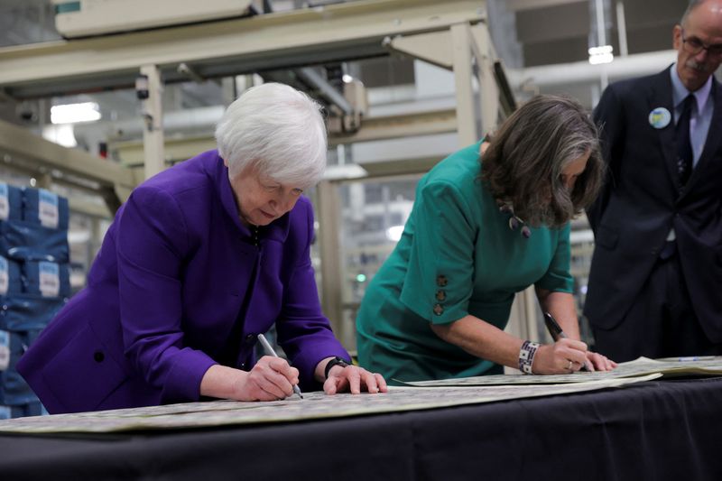 © Reuters. U.S. Treasury Secretary Janet Yellen and U.S. Treasury Chief Lynn Malerba sign on banknotes during  the unveiling of the first U.S. banknotes printed with two women's signatures at an event in Fort Worth, Texas, U.S., December 8, 2022.   REUTERS/Shelby Tauber