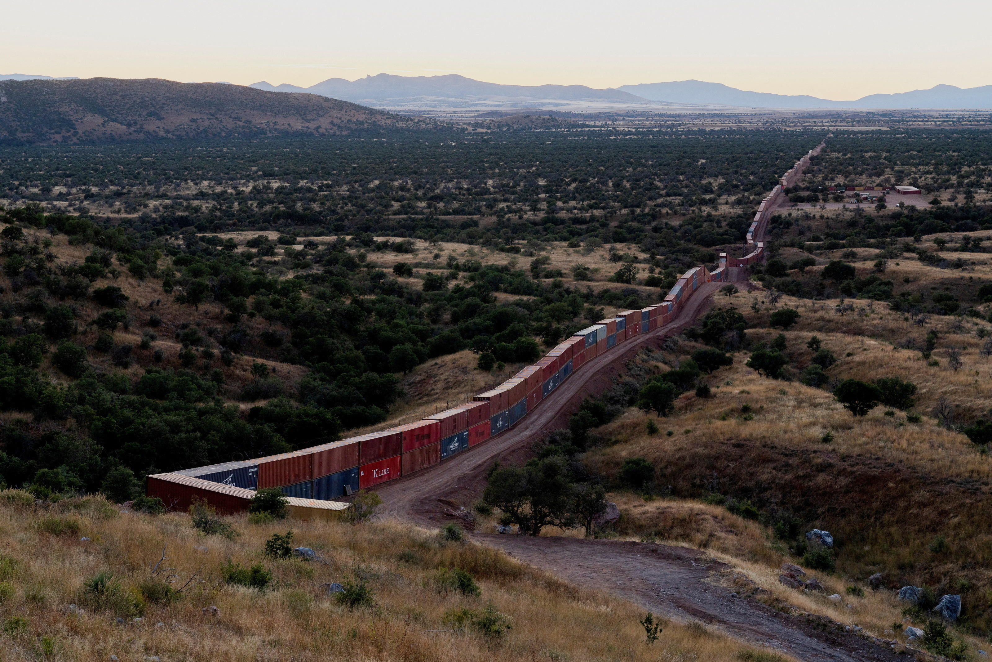 Border barrier of shipping containers snakes across Arizona wilderness