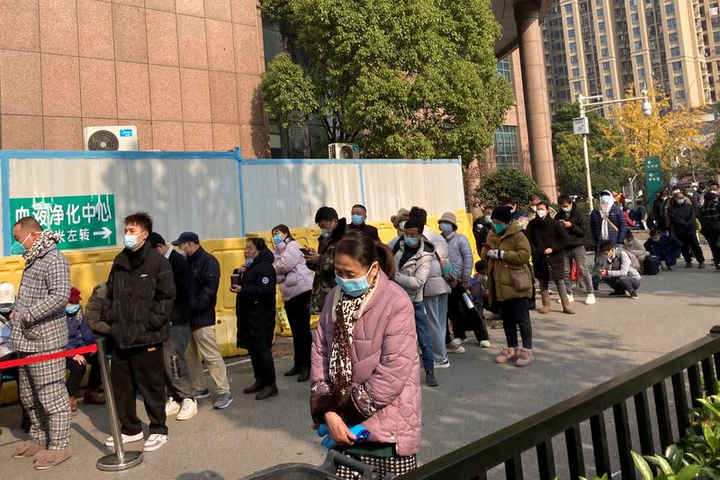 &copy; Reuters. أشخاص يقفون في طابور بمستشفى مركزي في مدينة ووهان بعد تخفيف الحكومة الصينية القيود لمكافحة انتشار فيروس كورونا يوم الخميس. تصوير: مارتين بو