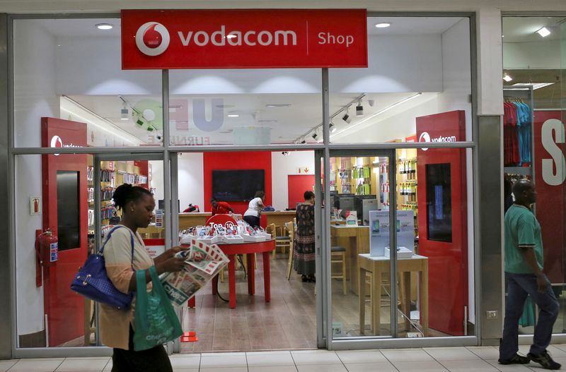 &copy; Reuters. FILE PHOTO: A shopper walks past a Vodacom shop in Johannesburg February 4, 2015. REUTERS/Siphiwe Sibeko/File Photo