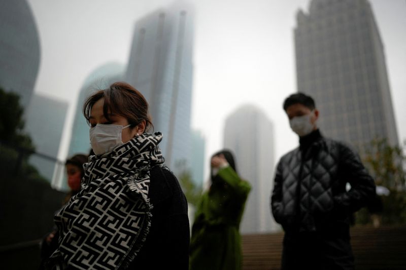 &copy; Reuters. People wearing masks walk at Lujiazui financial district, as coronavirus disease (COVID-19) outbreaks continue in Shanghai, China, December 9, 2022. REUTERS/Aly Song