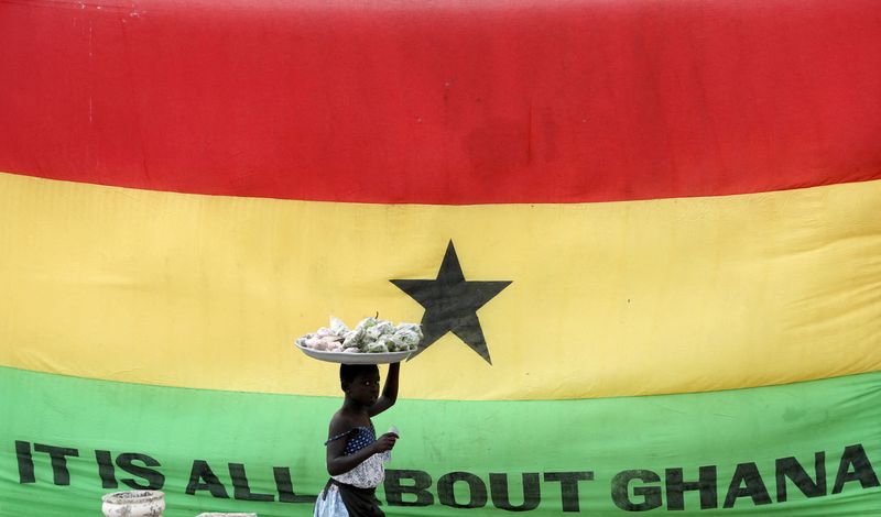 &copy; Reuters. FILE PHOTO: A girl walks past a flag of Ghana outside the Cape Coast Castle, in Ghana, July 28, 2019. REUTERS/Siphiwe Sibeko/File Photo