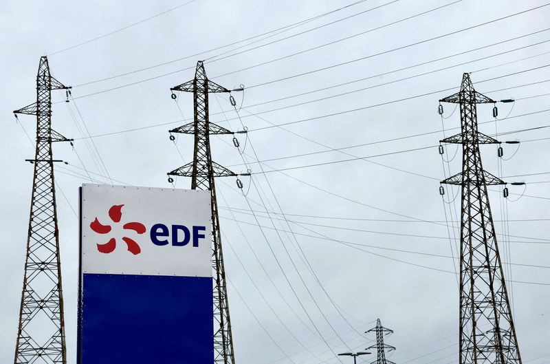 &copy; Reuters. Le logo d'Electricité de France (EDF) est visible devant les pylônes électriques du site de la centrale nucléaire du Tricastin à Saint-Paul-Trois-Chateaux. /Photo prise le 21 novembre 2022/REUTERS/Eric Gaillard