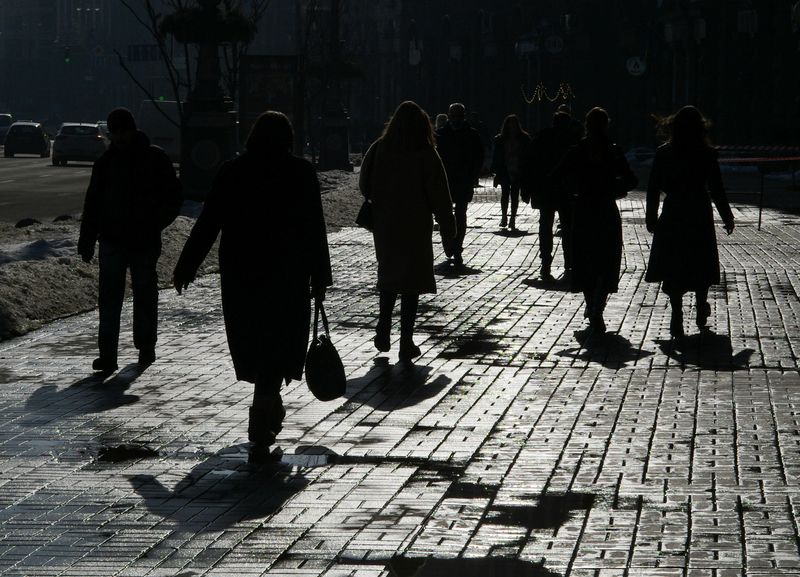 &copy; Reuters. FILE PHOTO: Pedestrians are silhouetted as they walk on a street during a sunny day in central Kyiv, Ukraine February 25, 2021. REUTERS/Gleb Garanich