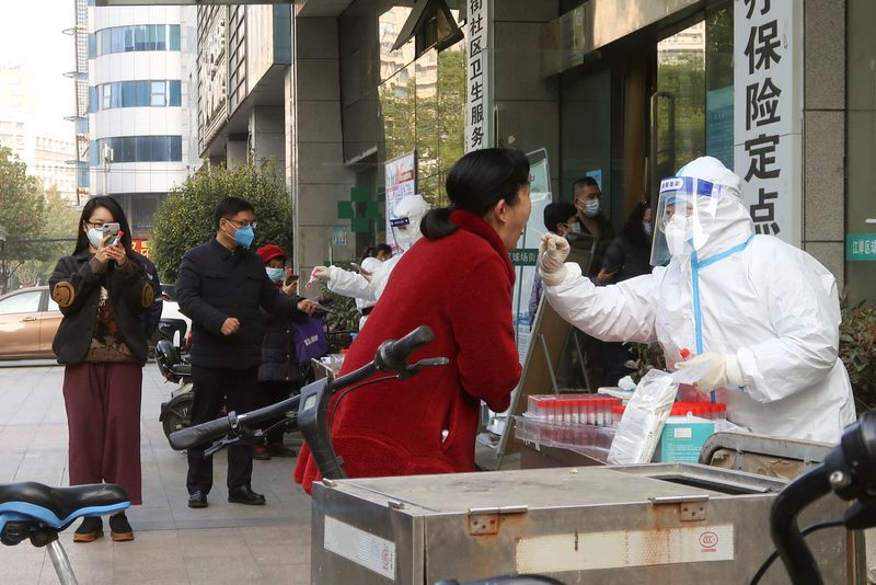 &copy; Reuters. Un trabajador médico toma una muestra de hisopo en una cabina de prueba para la enfermedad por coronavirus, después de que el gobierno aflojó gradualmente las restricciones sobre el control de COVID-19, en Wuhan, provincia de Hubei, China, el 9 de dici